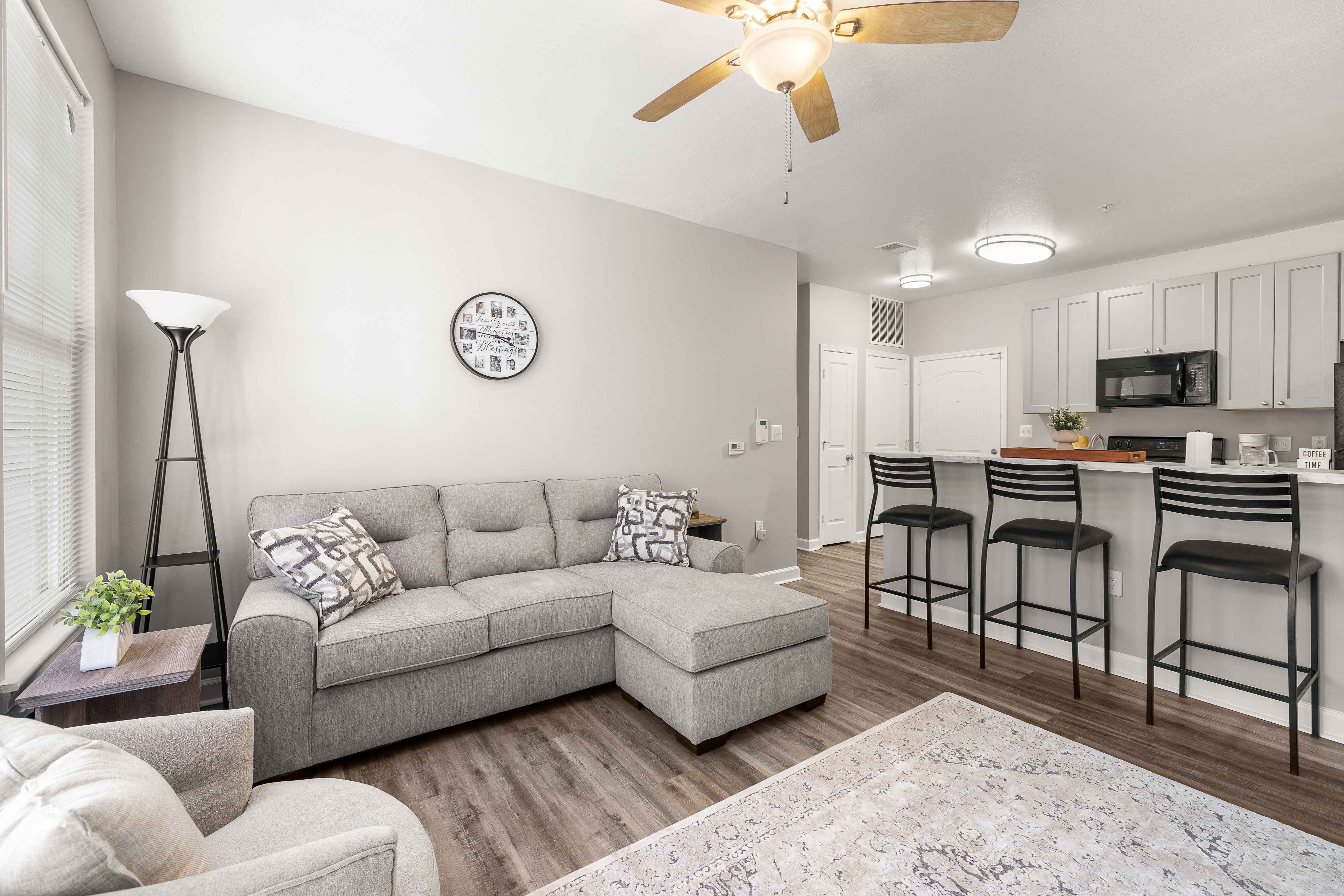 a living room with a couch and a kitchen with a breakfast bar